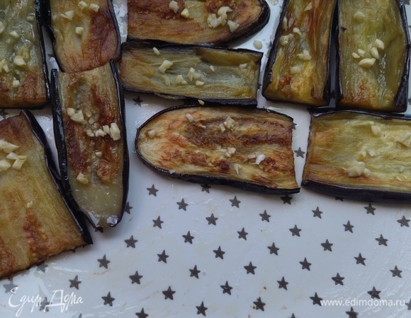 Обжаренные с обеих сторон баклажаны можно промокнуть салфеткой, убрав лишнее масло, выложить на тарелку в один слой. Сверху посыпать чесноком.