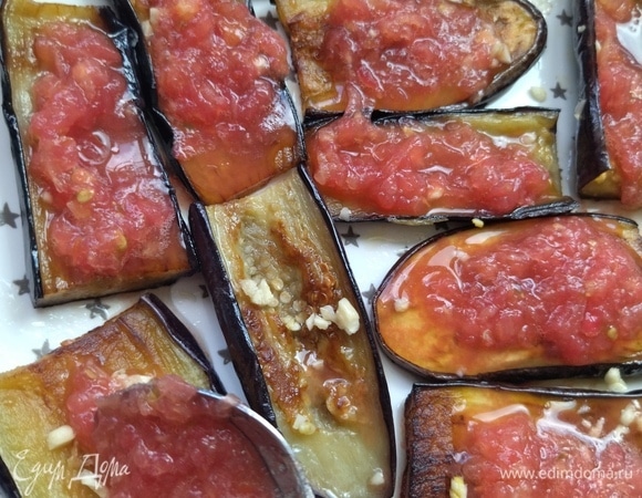 Выложить томат сверху на баклажаны.