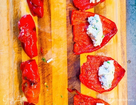 На половинки перцев выложить по 1 чайной ложке начинки и свернуть рулетом. Поставить в холодильник охладиться. Закуска готова.