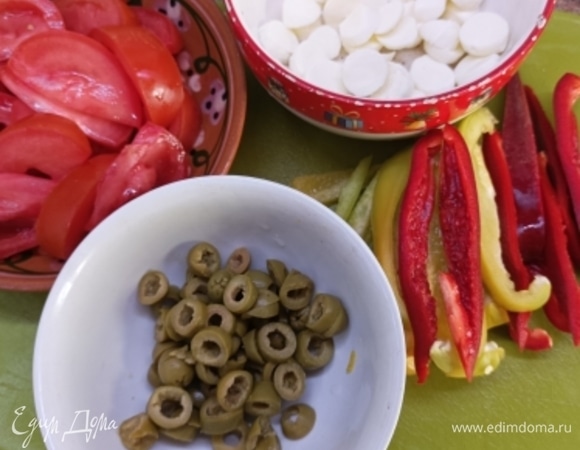 Перцы (любого цвета) нарежьте полосками. Оливки — кружочками. Помидоры — дольками, освободите от жидкости и семян. Моцареллу нарежьте или натрите крупно.