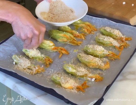 Твердый сыр натереть на мелкой терке, перемешать с сухарями и посыпать цукини.