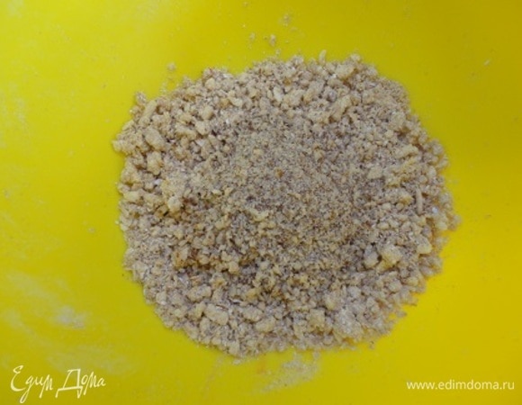 Яблоки (200 г — это чистый вес) очистить от сердцевины и нарезать кубиками. Для штрейзеля перетереть муку, сахар и масло в жирную крошку и соединить с измельченными орехами (орехи на ваш выбор). Убрать пока в холодильник. Включить духовку на 180°С.