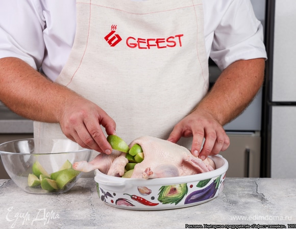 Наполните брюшко утки яблочными дольками. Те кусочки, что не поместятся, расположите вокруг тушки в форме для запекания.