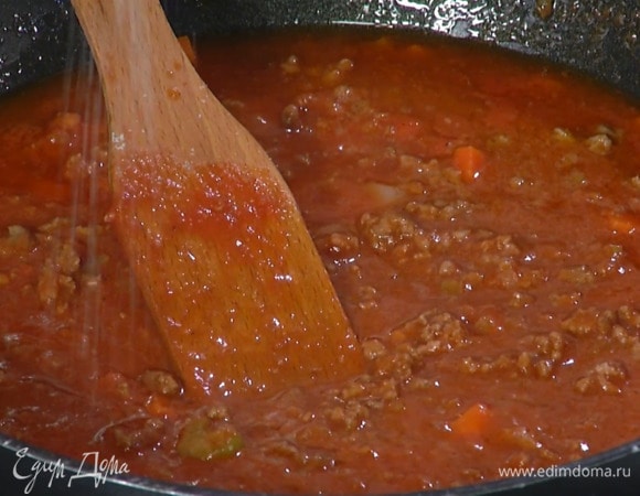 Фарш выложить к овощам и равномерно распределить лопаткой, добавить пассату и вино. Все посолить, перемешать, довести до кипения и томить на маленьком огне примерно полтора часа, затем добавить сливочное масло и перемешать.