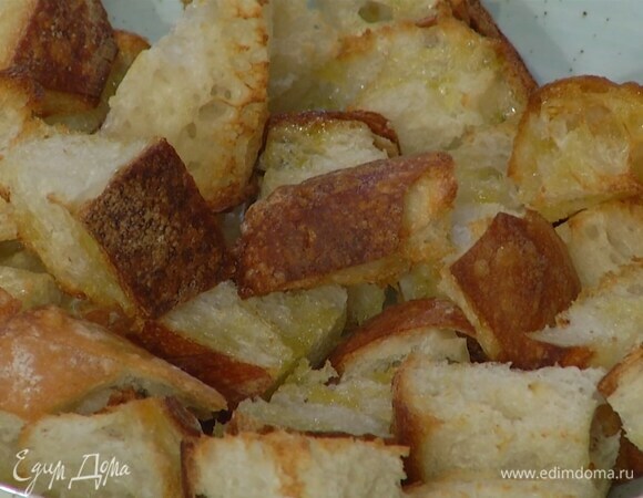 Хлеб нарезать кубиками или порвать на кусочки, выложить на выстеленный бумагой для выпечки противень, слегка сбрызнуть оливковым маслом и запекать в разогретой духовке 5–7 минут.