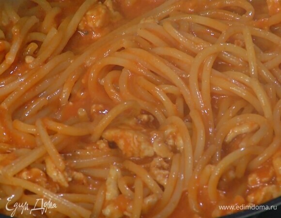 В сковороду с фаршем выложить спагетти, все перемешать, влить 50 мл воды, в которой варились макароны, и, помешивая, прогревать пару минут.
