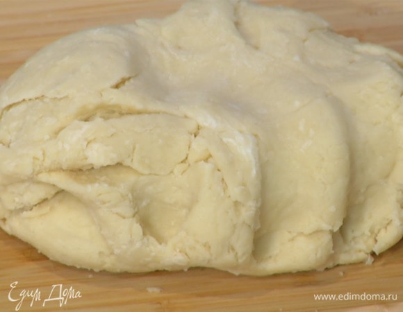 В творожную массу порциями всыпать муку и вымешать лопаткой.