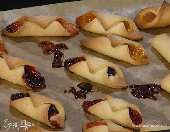 Переложить бумагу с печеньем на противень и выпекать в разогретой духовке 15–18 минут.