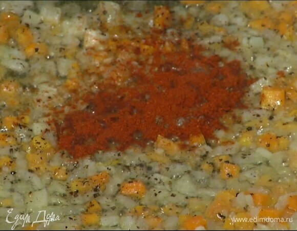 Морковь почистить, нарезать маленькими кубиками и добавить к луку с чесноком, всыпать соль, перец, паприку и перемешать.