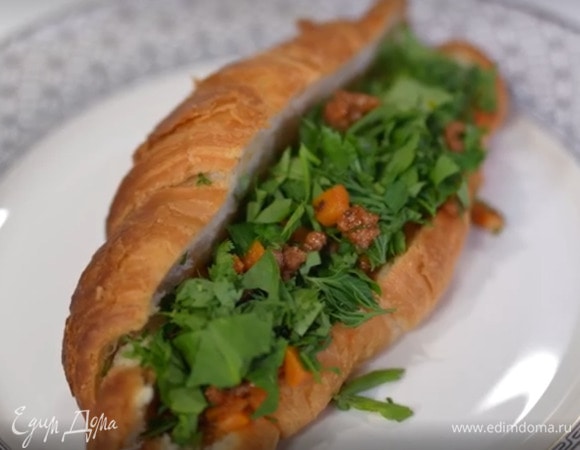 Готовые круассаны разрезать вдоль пополам, не прорезая до конца, затем раскрыть, выложить фарш вместе с соусом и посыпать зеленью.
