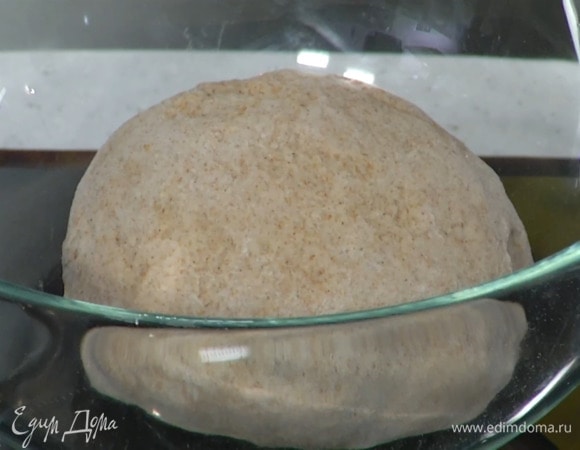 Выложить тесто на рабочую поверхность, посыпанную оставшейся мукой, и сформировать шар, затем поместить его в миску, накрыть влажным полотенцем и оставить на 20–30 минут.