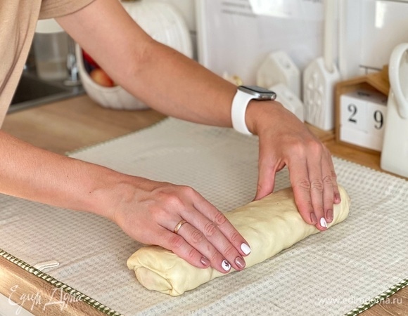Тесто переложить на полотенце и раскатать в тонкий прямоугольник. Равномерно распределить начинку, отступив от краев на 3 см. Смазать края маслом и скрутить штрудель с помощью полотенца. Положить на противень швом вниз, смазать маслом или яйцом и выпекать 30–35 минут.