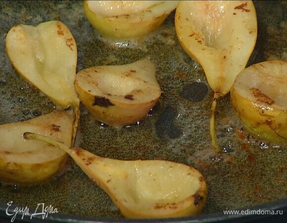 Растопить в тяжелой сковороде сливочное масло, выложить груши срезом вниз и обжаривать до появления румяной корочки.