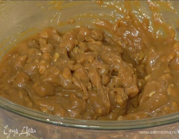 Приготовить крем: оставшееся сливочное масло растопить на маленьком огне, тонкой струйкой влить в сгущенку и вымешать венчиком, затем добавить орехи и все перемешать.