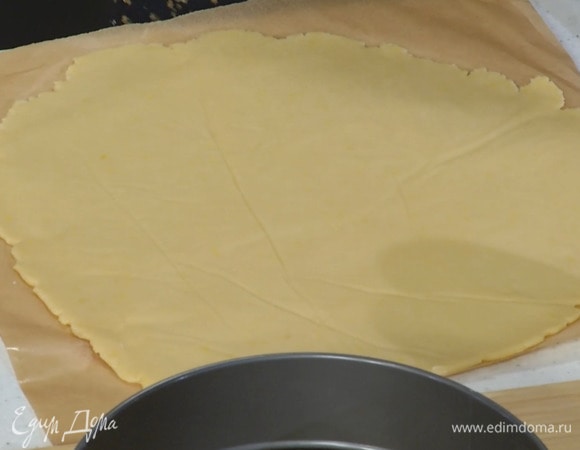 Яйцо размешать вилкой, половину влить в тесто и еще немного взбить, затем раскатать тесто между двумя листами бумаги для выпечки.
