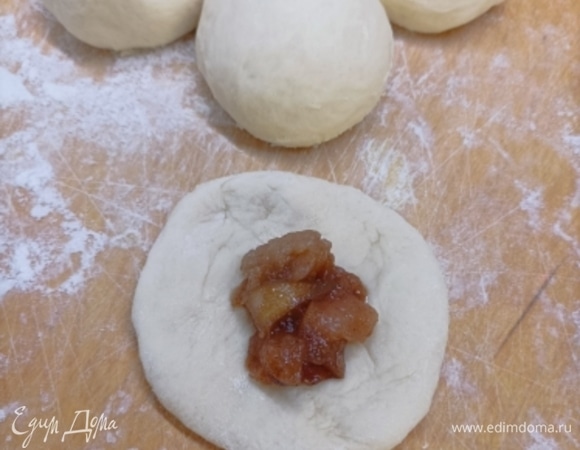 Подошедшее тесто делим на 12 равных частей и формируем из каждой шарик. Раскатываем каждый кусочек, в центр помещаем начинку.