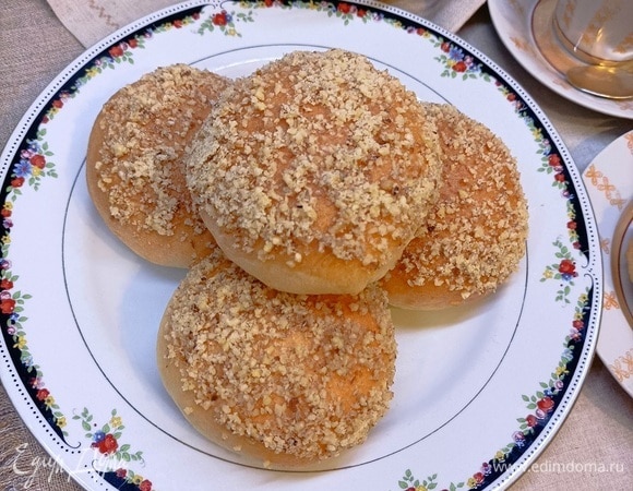 Даем булочкам немного остыть и покрываем их смесью из меда и растопленного сливочного масла и обваливаем в дробленых орехах.