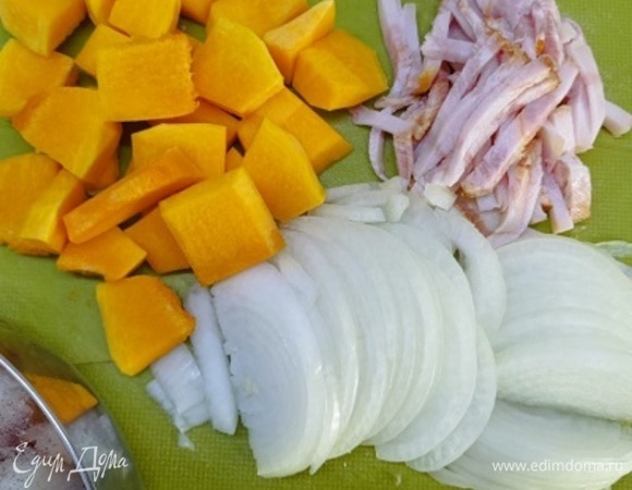 Тыкву нарезать крупными кубиками, бекон — полосками, лук — полукольцами.