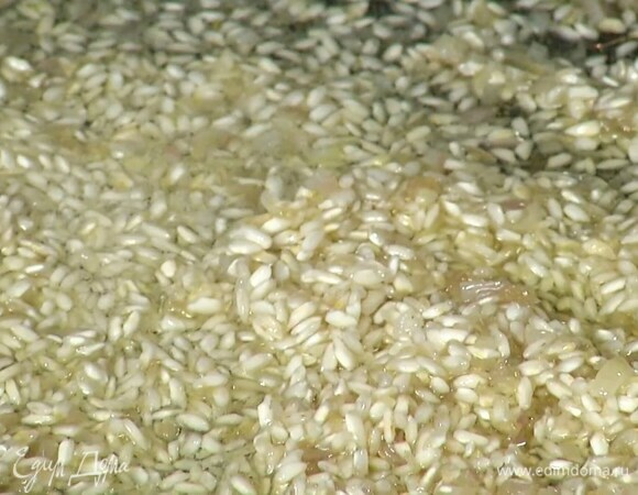 Разогреть в сковороде 2 ст. ложки оливкового масла и обжарить лук до прозрачности, затем всыпать рис и сделать тостатуру.