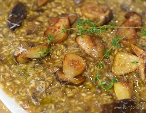 Выложить ризотто на плоскую тарелку, украсить обжаренными грибами, сбрызнуть оливковым маслом Extra Virgin, сверху разложить свежие веточки тимьяна, посыпать все оставшимся сыром.