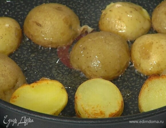 Картофель отварить в мундире и, не очищая, разрезать пополам, затем выложить срезами вниз в сковороду с разогретым оливковым маслом и обжаривать до появления золотистой корочки.