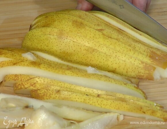 Грушу разрезать пополам, вырезать сердцевину, затем положить срезом вниз и нарезать вдоль тонкими ломтиками.