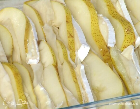 В складки теста выложить попеременно ломтики сыра и груши, полить все растопленным маслом, затем сливками с яйцами.