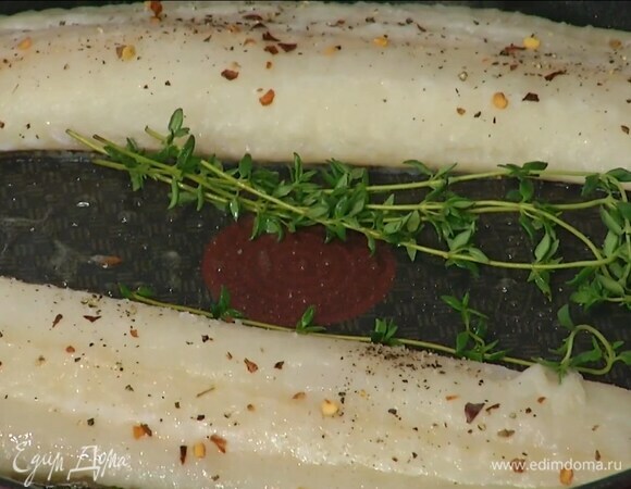 Разогреть в отдельной сковороде оставшееся оливковое масло, выложить рыбу кожей вниз, посолить, поперчить, посыпать хлопьями паприки и, вложив между филе веточки тимьяна, обжарить с двух сторон до готовности.