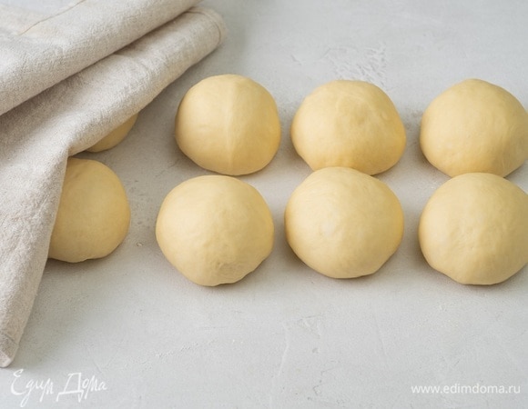 Смажьте руки растительным маслом и разделите заготовку на 10 равных кусочков. Сформируйте из каждого шарик и уберите под полотенце.
