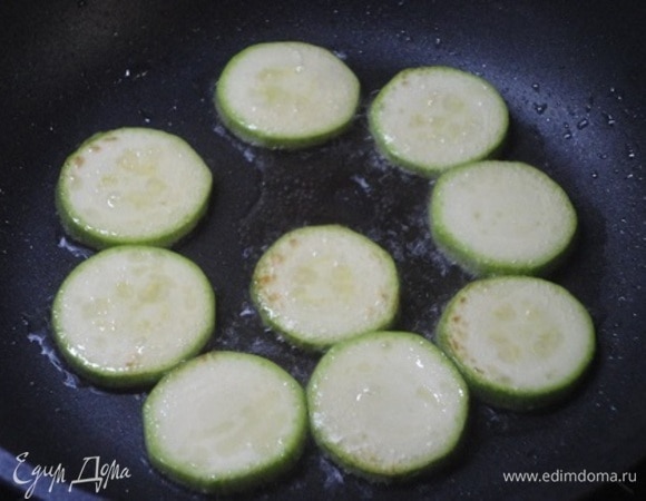 Молодые кабачки нарезать кружочками и слегка обжарить с двух сторон. Выложить на бумажные полотенца, чтобы удалить лишнее масло.