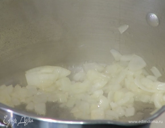 Лук почистить и нарезать маленькими кубиками, затем в кастрюле с тяжелым дном разогреть оливковое масло и обжарить лук до прозрачности.