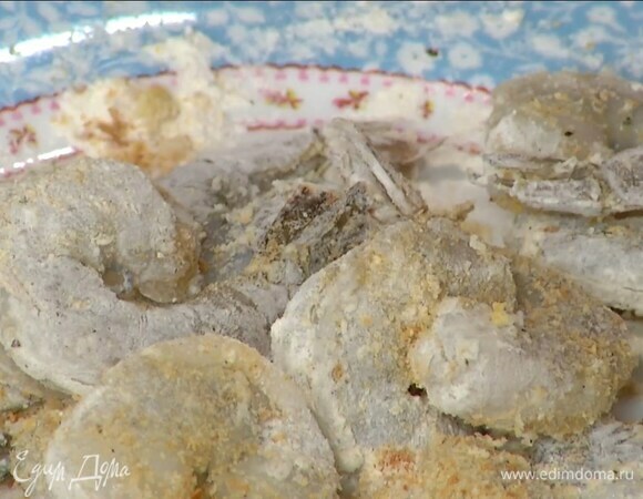 Муку, сухари и сушеный чеснок, всыпать в тарелку, добавить соль, свежемолотый перец, перемешать и обвалять креветки со всех сторон.