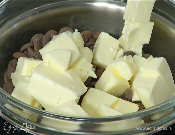 Нарезать кубиками 150 г сливочного масла, выложить в кастрюлю, добавить шоколад и растопить все на водяной бане.