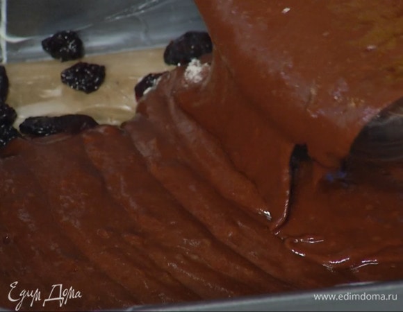 Дно квадратной разъемной формы выстелить бумагой для выпечки, смазать все оставшимся сливочным маслом, выложить вишню и залить шоколадным тестом.