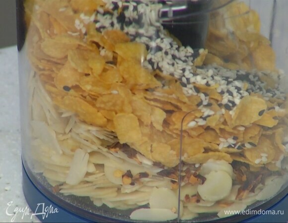 В чашу блендера всыпать миндальные и кукурузные хлопья, кунжут, чили, соль и все измельчить.