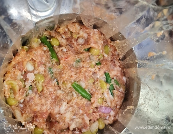 В фарш добавить специи и соль, перемешать с добавлением воды. Хорошо вымешать до липкого состояния ингредиентов. Добавляем желатин, горошек с фасолью, лук и перемешиваем.