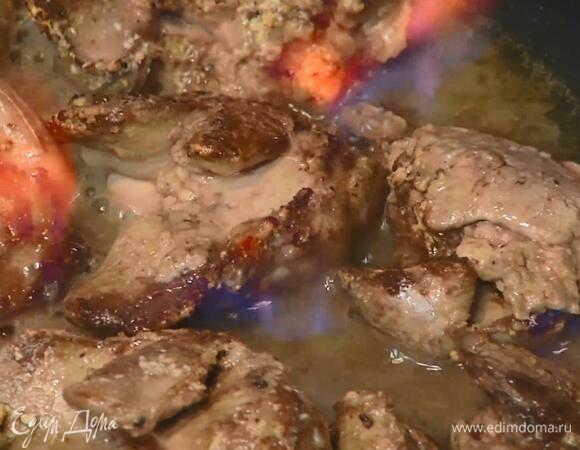 Разогреть в сковороде оливковое масло и обжаривать печень на сильном огне до появления золотистой корочки с одной стороны, затем перевернуть, влить коньяк и поджечь его, сделав фламбе.