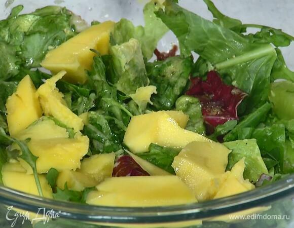 Из манго вырезать мякоть, нарезать кусочками, добавить к салату и перемешать.