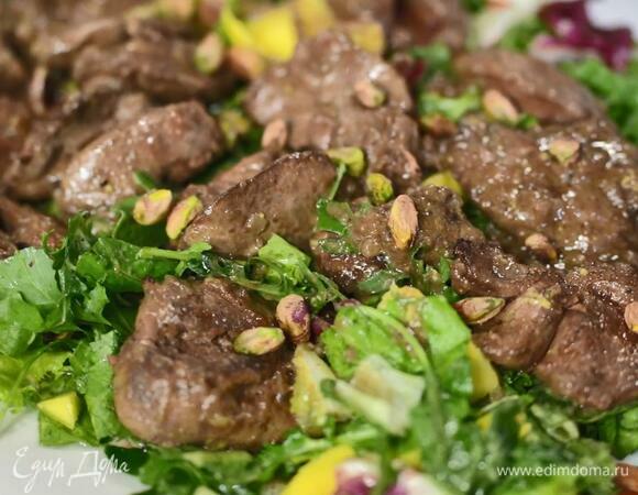 Выложить салат на тарелку, сверху поместить обжаренную печень и посыпать все фисташками.