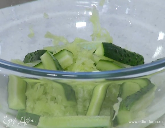 Огурец нарезать вдоль полосками, затем разрезать пополам.