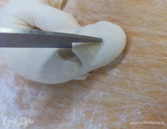 Сворачиваем заготовку в кольцо, один край которой приплющиваем, а второй укладываем на него. Защипываем снизу края, чтобы в процессе выпечки кольцо не раскрылось.