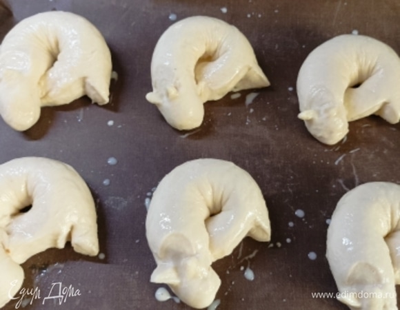 Выкладываем булочки на противень, застеленный пекарской бумагой, даем подойти под полотенцем около 15 минут. Смазываем поверхность смесью желтка и молока .