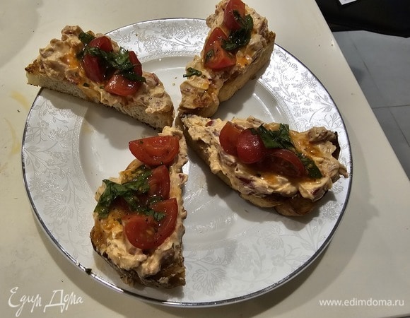 Нарезать помидоры черри на четвертинки. Смешать их с оливковым маслом, нарезаным запеченным перцем (нужна половика перца), мелко нарезанной кинзой и мятой. Добавить соль, перец, щепотку сахара. Выложить томаты сверху на тапас с сырной намазкой