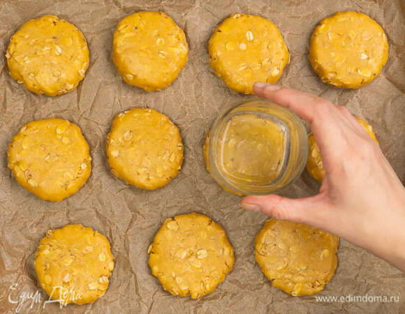 Разделите тесто на несколько частей и скатайте кружочки. Придавите их с помощью стакана, чтобы они приобрели форму шариков.