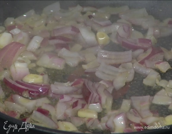 Красный лук и чеснок почистить, мелко порубить и обжарить на разогретом в сковороде оливковом масле.