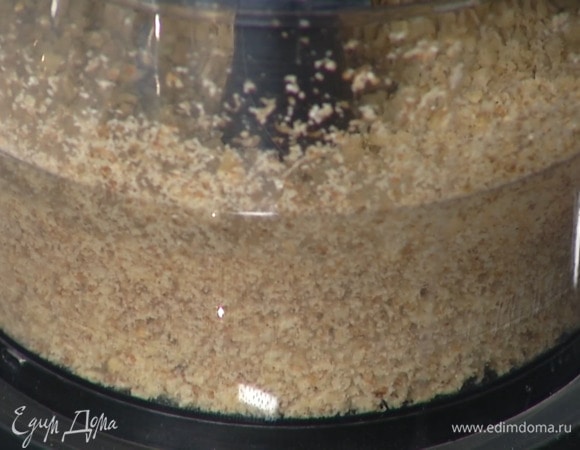 Орехи измельчить в блендере в мелкую крошку, всыпать сахар и измельчить еще немного, затем добавить 100 г предварительно размягченного сливочного масла, всыпать щепотку соли и все еще раз вымешать блендером.