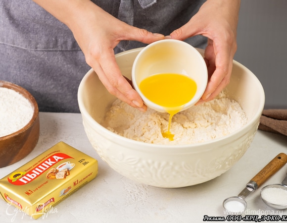 В миску просейте муку, добавьте соль, сахар и маргарин «Пышка». Руками замесите тесто.