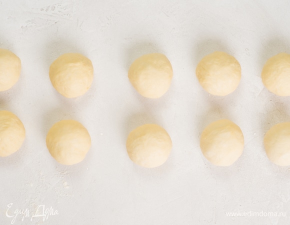 Посыпьте рабочую поверхность мукой. Положите тесто и разделите его на 10–12 частей.