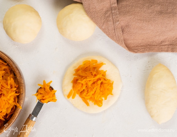 Раскатайте каждый шарик в лепешку толщиной в 1–1,5 см. Внутрь выложите 2 чайных ложки начинки. Сделайте защипы по краям.