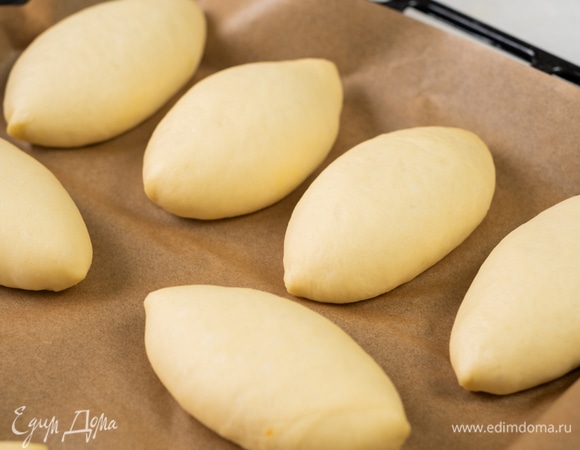 Застелите противень бумагой для выпечки. Выложите пирожки на расстоянии друг от друга. Накройте их полотенцем и оставьте на 20 минут.